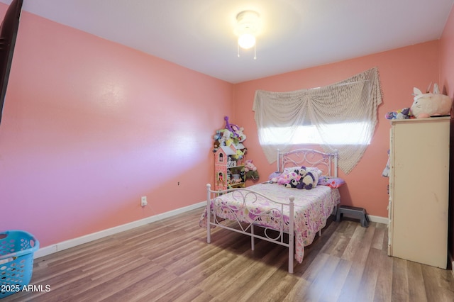 bedroom with baseboards and wood finished floors