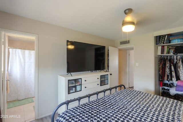 bedroom with visible vents, a closet, tile patterned flooring, and ensuite bath
