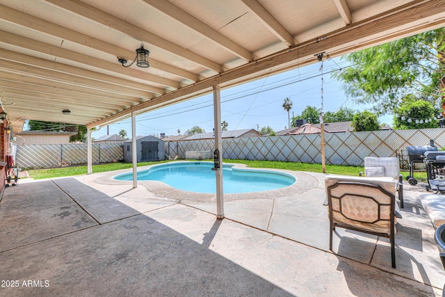 view of pool featuring a patio, an outbuilding, a fenced backyard, and a storage shed