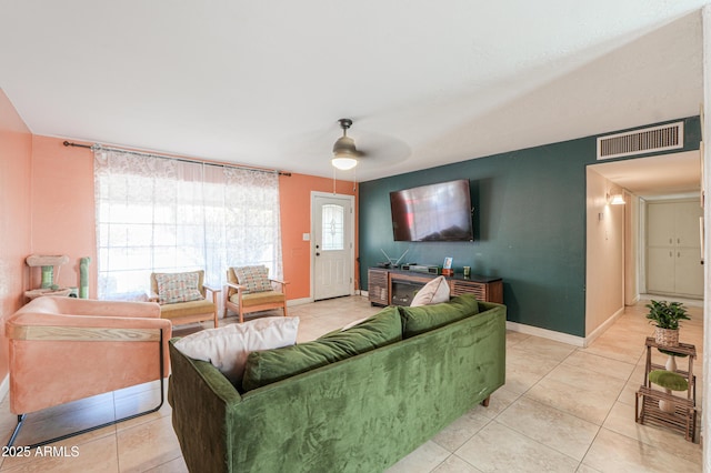 living area with a ceiling fan, light tile patterned floors, baseboards, and visible vents