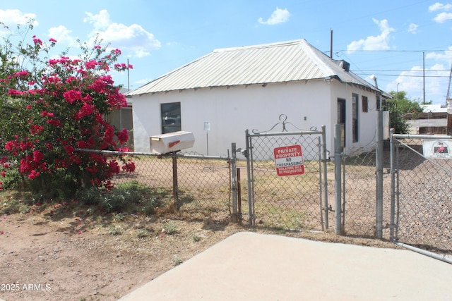 2016 W Hadley St, Phoenix, AZ 85009 - view of side of home featuring a gate, stucco siding, and metal roof