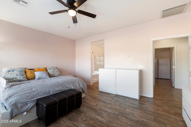 bedroom featuring ensuite bathroom, white refrigerator, dark hardwood / wood-style flooring, and ceiling fan