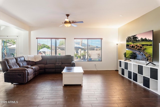 living room featuring ceiling fan and dark wood-type flooring