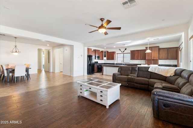 living room featuring ceiling fan, dark hardwood / wood-style flooring, and sink