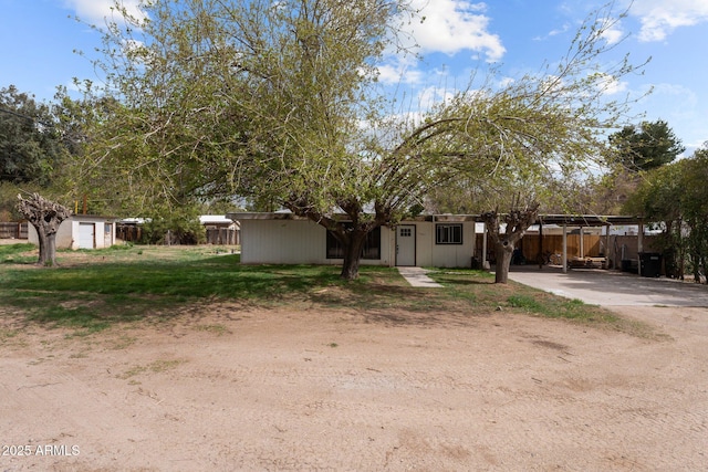 view of front of home with an outbuilding, fence, and a storage shed