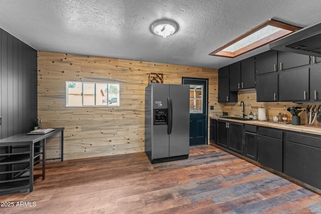 kitchen with a sink, a skylight, stainless steel fridge, and dark wood-style flooring