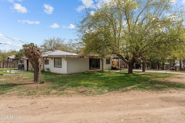 rear view of house with a lawn and fence