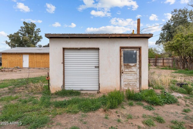 view of outdoor structure featuring an outbuilding and fence