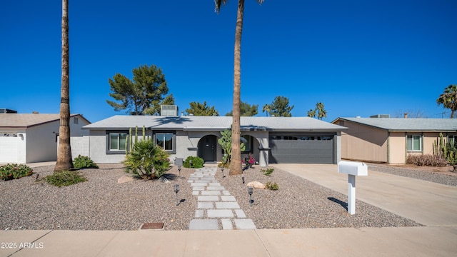 single story home with stucco siding, an attached garage, and driveway