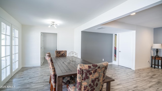 dining room with visible vents, baseboards, and light wood-style floors