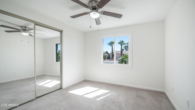 unfurnished bedroom with a closet, carpet flooring, ceiling fan, and baseboards