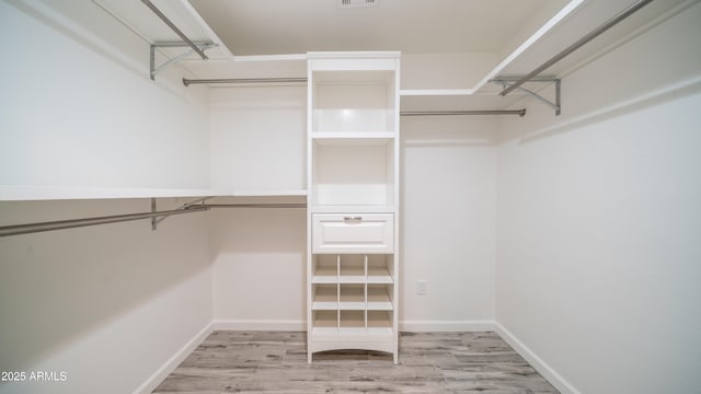 spacious closet featuring visible vents and wood finished floors