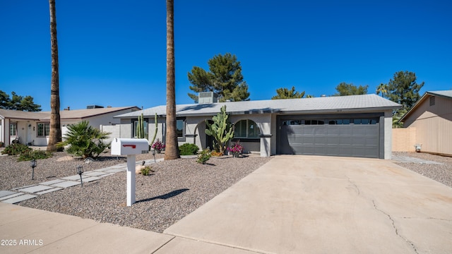 view of front of house with an attached garage, fence, driveway, and stucco siding