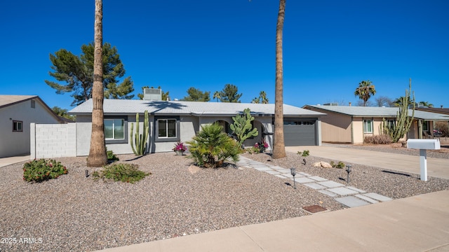 view of front of home with driveway, a garage, and fence