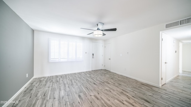 unfurnished room with visible vents, baseboards, wood finished floors, and a ceiling fan