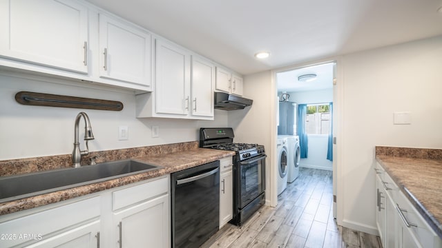 kitchen with black gas stove, a sink, dishwasher, under cabinet range hood, and washer and dryer