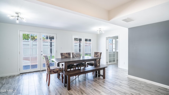 dining area with light wood-style floors, french doors, visible vents, and baseboards