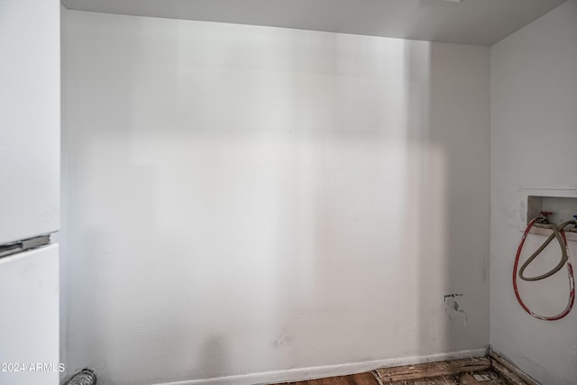 interior space with laundry area, washer hookup, and wood finished floors