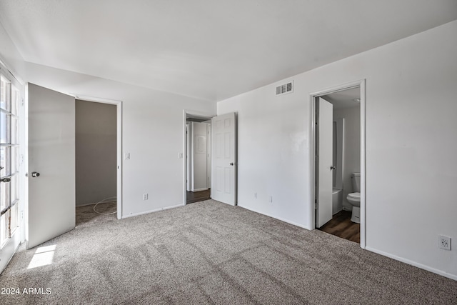 unfurnished bedroom featuring carpet, visible vents, and connected bathroom