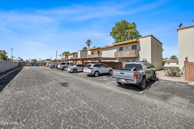 partially covered parking lot featuring fence