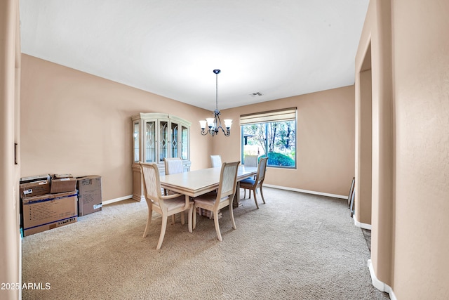 carpeted dining room with a chandelier