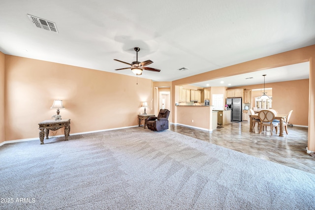 unfurnished living room with light colored carpet and ceiling fan