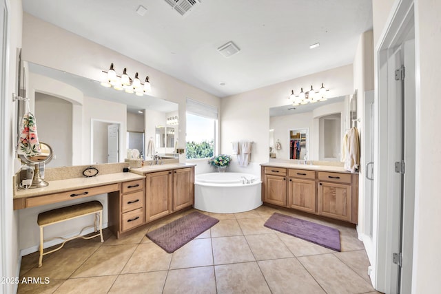 bathroom featuring tile patterned flooring, vanity, and a washtub