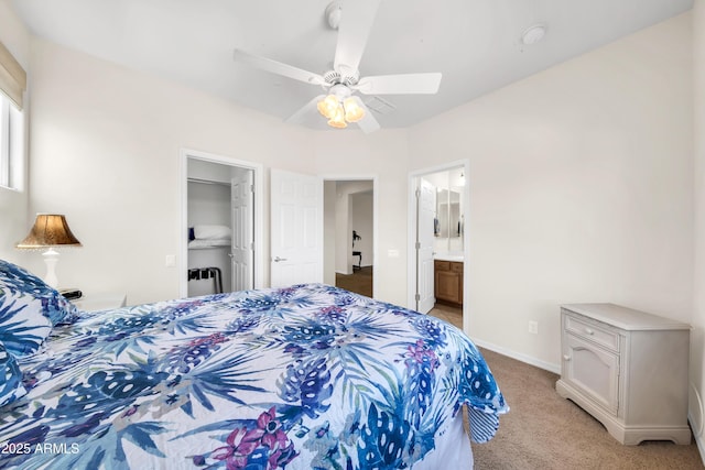 bedroom featuring ceiling fan, ensuite bathroom, light carpet, a spacious closet, and a closet