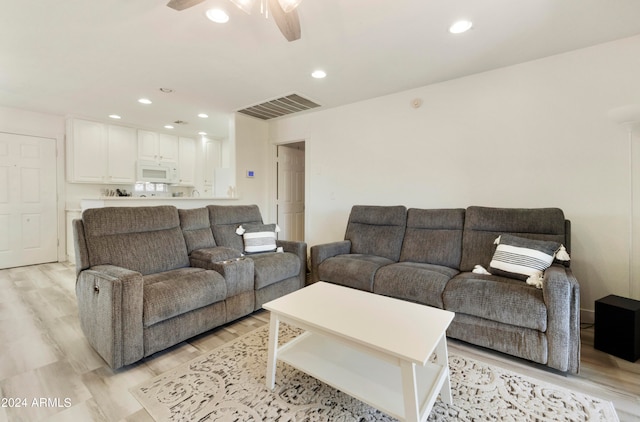 living room featuring ceiling fan and light hardwood / wood-style flooring