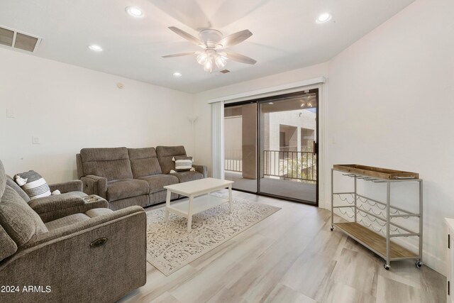 living room with ceiling fan and light wood-type flooring