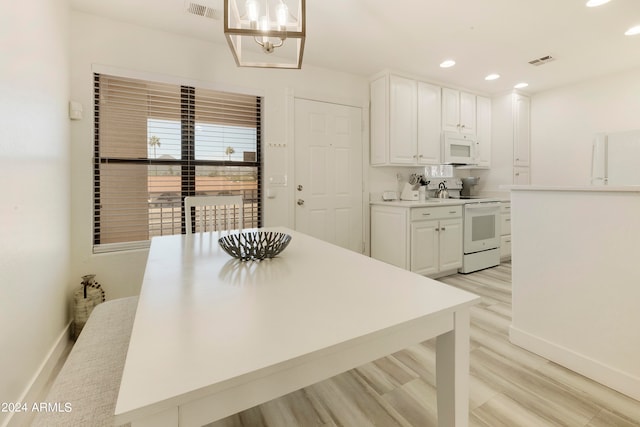 kitchen featuring a notable chandelier, decorative light fixtures, white appliances, white cabinets, and light wood-type flooring