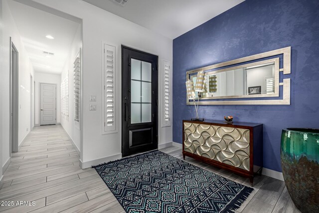 entryway featuring wood tiled floors and baseboards