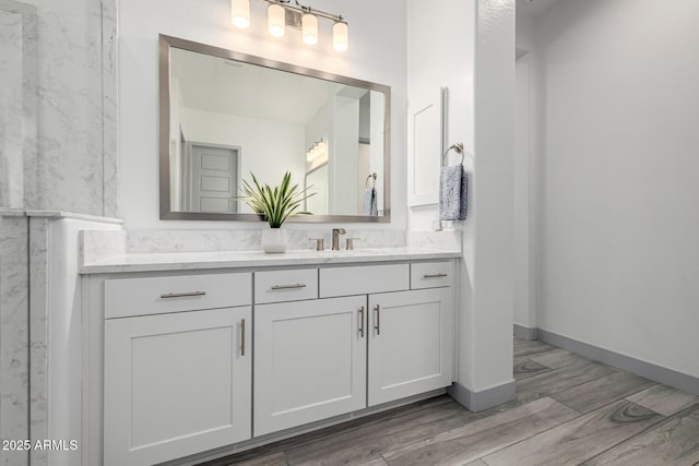 bathroom featuring wood finished floors, vanity, and baseboards