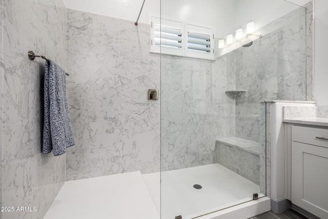 bathroom featuring a walk in shower and vanity