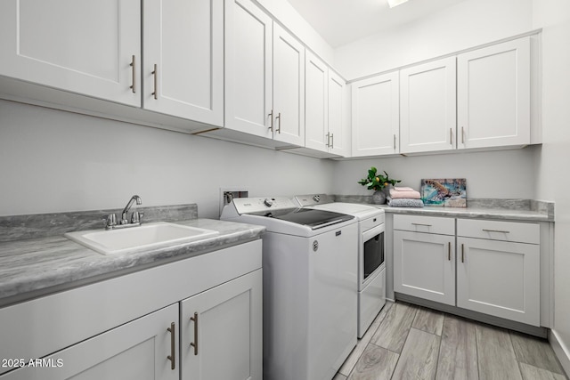 clothes washing area with washer and clothes dryer and cabinet space