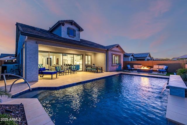 pool at dusk featuring an outdoor living space with a fire pit, a patio area, and a fenced backyard
