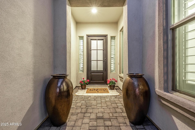 entryway with a textured wall and brick patterned floors