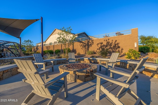 view of patio with an outdoor fire pit and fence