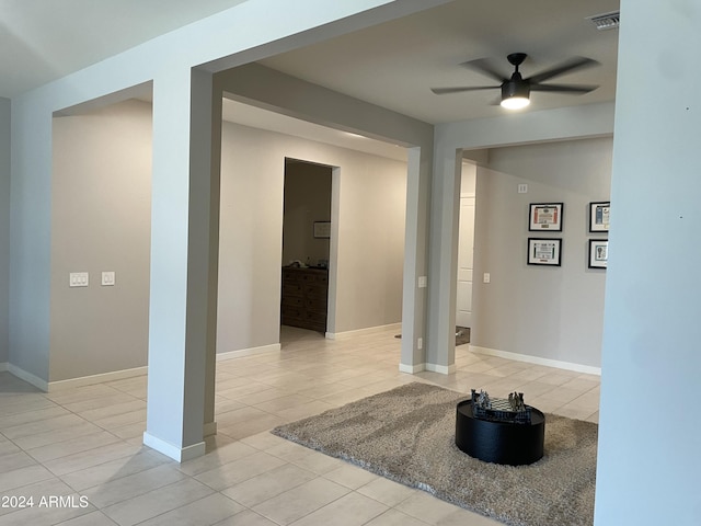 interior space featuring visible vents, ceiling fan, baseboards, and light tile patterned floors