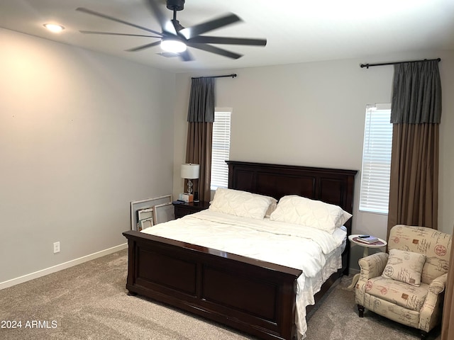 bedroom featuring baseboards, a ceiling fan, and light colored carpet