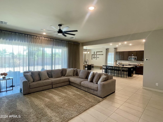 living room with light tile patterned floors, baseboards, visible vents, a ceiling fan, and recessed lighting