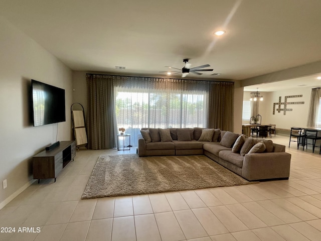 living room featuring light tile patterned floors, recessed lighting, visible vents, and ceiling fan with notable chandelier