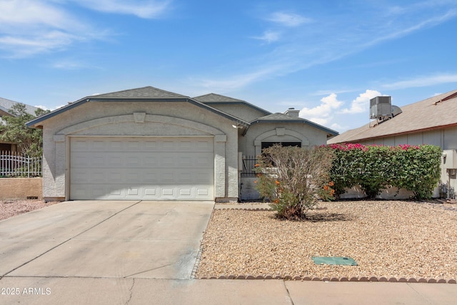 6938 W Nicolet Ave, Glendale, AZ 85303 - view of front of property with concrete driveway, a garage, stucco siding, and central AC