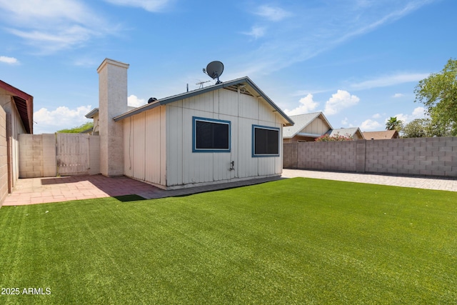 6938 W Nicolet Ave, Glendale, AZ 85303 - back of property with board and batten siding, a patio, and a chimney