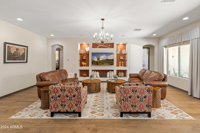 living room with a chandelier and light hardwood / wood-style flooring