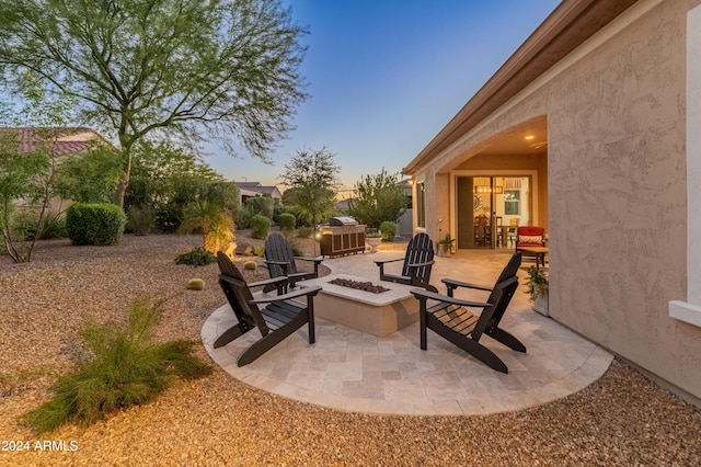 patio terrace at dusk featuring an outdoor fire pit