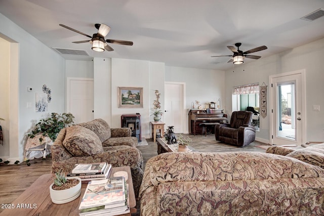 living area with visible vents, ceiling fan, and wood finished floors