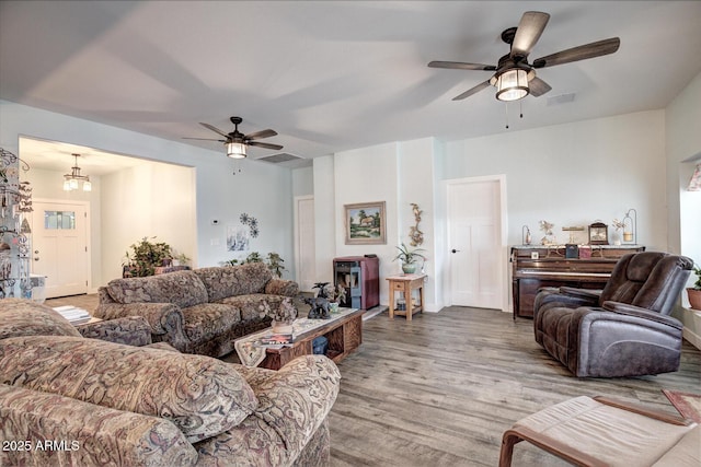 living room with wood finished floors, a ceiling fan, and visible vents