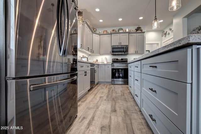 kitchen featuring light stone countertops, recessed lighting, gray cabinets, light wood-style floors, and stainless steel appliances