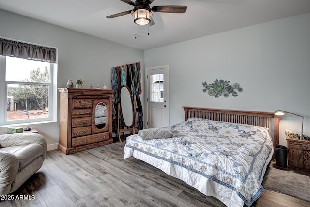 bedroom with multiple windows, a ceiling fan, and wood finished floors